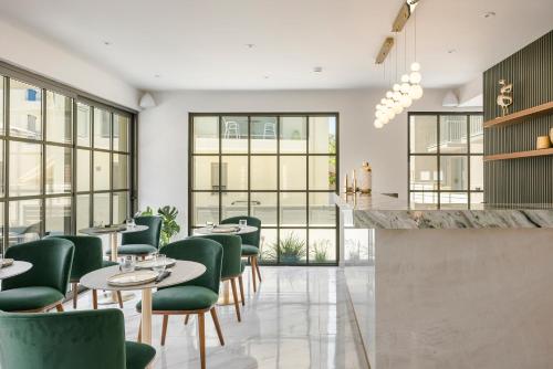 a restaurant with green chairs and tables at G Boutique Hotel Kefalonia in Argostoli