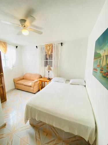 a white bedroom with a bed and a couch at Adouly Plaza Hotel in Saint-Raphaël