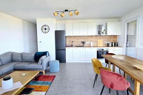 une cuisine et un salon avec une table et des chaises dans l'établissement L'Horizon Léman, à Évian-les-Bains