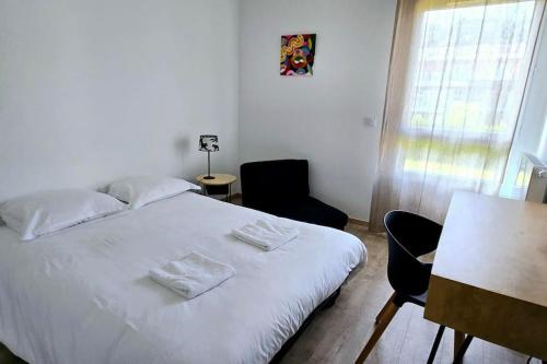 - une chambre avec un lit blanc, une table et des chaises dans l'établissement L'Horizon Léman, à Évian-les-Bains