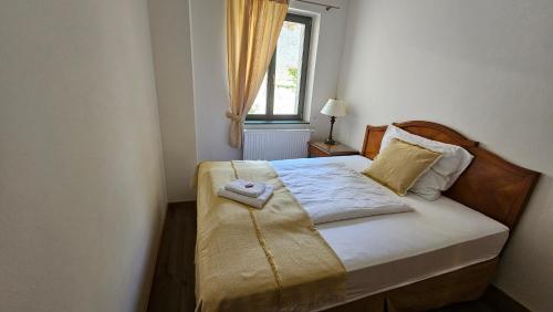 a small bedroom with a bed with a window at Hotel Opat in Kutná Hora