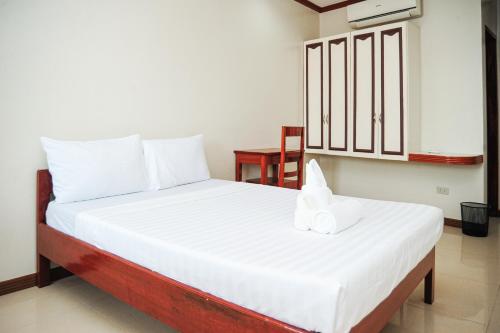 a bedroom with a bed with white sheets and white pillows at Kaia Isabelle Inn in Puerto Princesa City