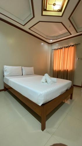 a large bed in a room with a ceiling at Kaia Isabelle Inn in Puerto Princesa City
