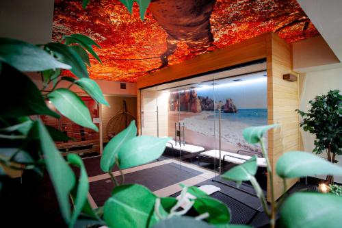 a room with plants and a room with a ceiling at Hotel & SPA Odeon in Boguchwała