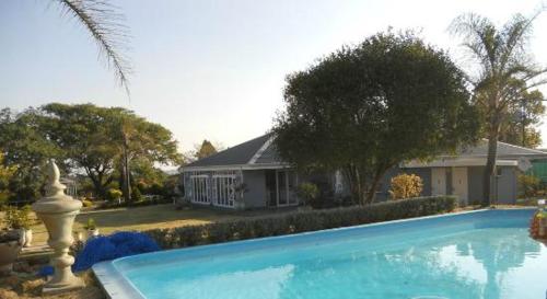 een groot blauw zwembad voor een huis bij Nauntons Guest House & Wedding Venue in Ladysmith