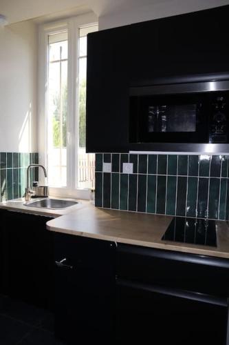 a kitchen with a sink and a microwave at Le Ciné-Nid in Moulins