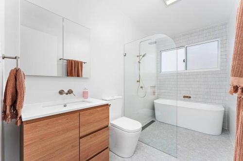 Un baño con bañera, inodoro y lavabo. en The White House near beach & shops, en Corrimal