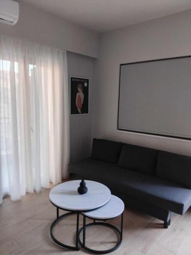 a living room with a couch and a white table at Simple, Calm and Luxurious in Kalamata