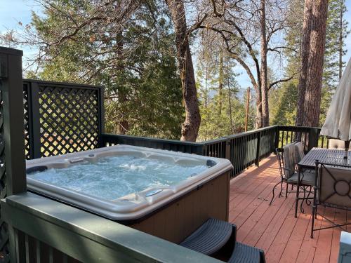 un bain à remous sur la terrasse d'une maison dans l'établissement Sugar Pine Haus- A Frame Cabin w/ Hot Tub, à Yosemite Forks