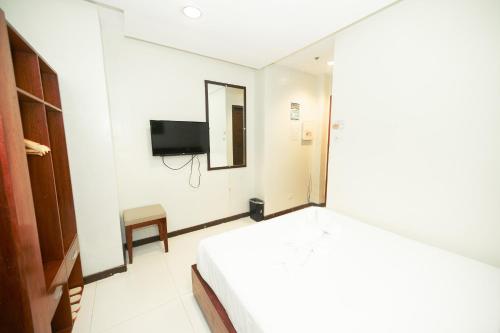a bedroom with a bed and a tv on the wall at Marianne Hotel in Puerto Princesa City