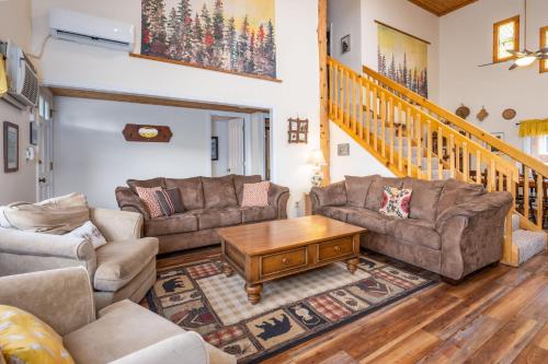 a living room with two couches and a table at Selah Cabin- Dog Friendly/BBQ/Level 2 EV Charger in Yosemite Forks
