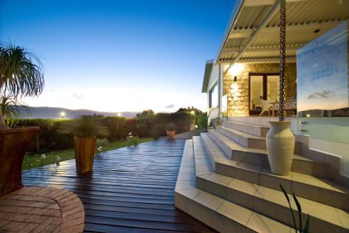 a house with steps leading up to a house with the sunset at Candlewood Lodge in Knysna