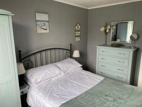 a bedroom with a bed with a dresser and a mirror at Kebbles retreat in Mablethorpe