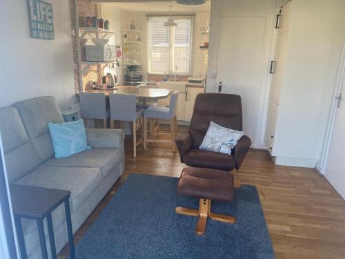a living room with a couch and a chair and a kitchen at Kebbles retreat in Mablethorpe