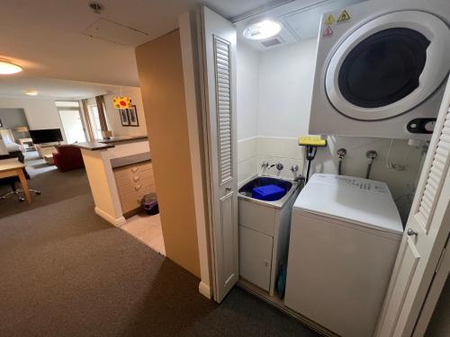 a laundry room with a washing machine and a washer at Hotel styling entire one bedroom in Sydney