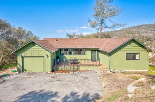 a green house with a garage in a yard at Buckeye Bungalow w hot tub/firepit/views Pet Friendly in Oakhurst