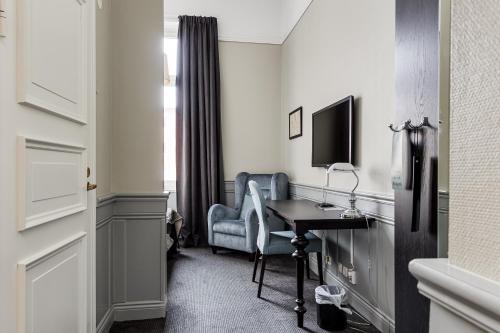 a hotel room with a desk and a chair at Home Hotel Post in Oskarshamn