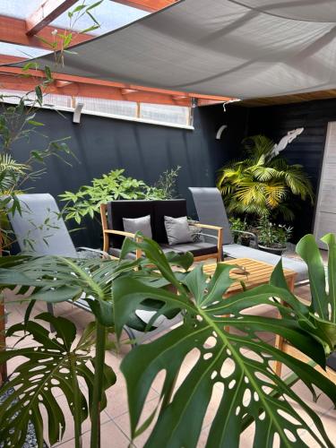 a patio with chairs and potted plants at Vulkan’O in La Plaine des Cafres