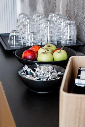 two bowls of apples and glasses on a table at Home Hotel Post in Oskarshamn