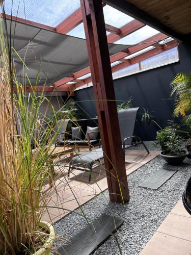 a patio with chairs and plants in a house at Vulkan’O in La Plaine des Cafres