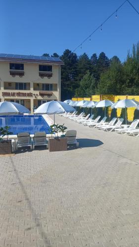 a group of chairs and umbrellas in a parking lot at ȘURA LU' PĂTRU in Vulcan