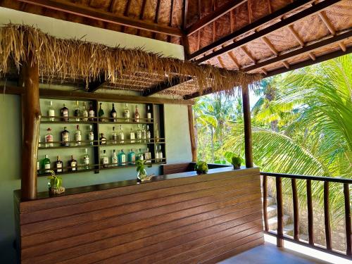 a bar with green bottles on the wall at Jungle Paradise in Nusa Penida