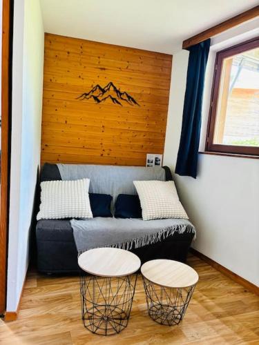 un salon avec un canapé et deux tables dans l'établissement La Parenthèse Chamroussienne - Proche pistes de ski, à Chamrousse