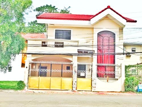 a house with a red door and a garage at Mactan Cebu Home in Lapu Lapu City