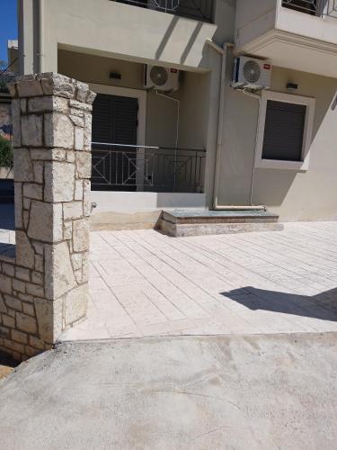 a house with a stone pillar in front of a building at Simple, Calm and Luxurious in Kalamata