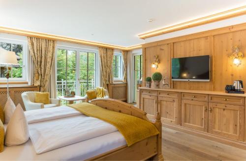 a bedroom with a bed and a flat screen tv at Via Salina - Hotel am See - Adults Only in Haldensee