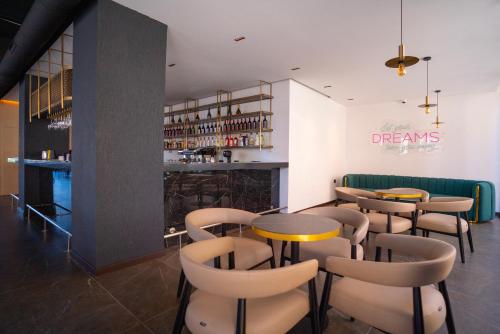 a restaurant with tables and chairs and a bar at DREAM HOTEL SARANDA in Sarandë