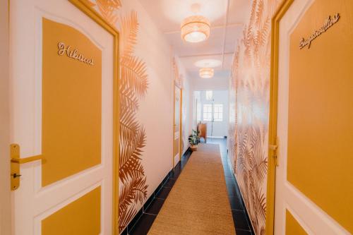 a hallway with yellow walls and a hallway with a door at La villa du jardin in Saint-Denis