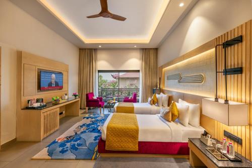 a hotel room with a bed and a living room at Ananta Spa & Resort Jaipur in Jaipur
