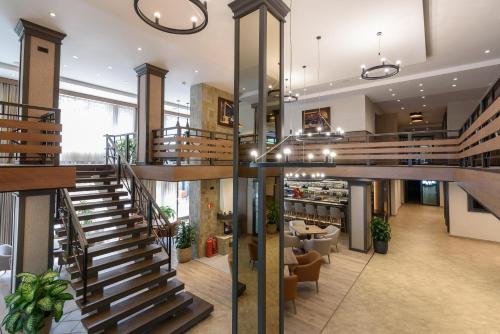 a lobby with wooden stairs and a restaurant at Lion Hotel Borovets in Borovets