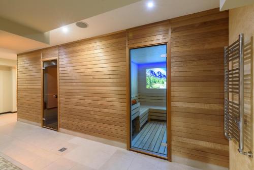 a sauna with wooden walls and a glass door at Lion Hotel Borovets in Borovets
