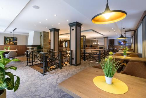 a lobby with tables and chairs and a dining room at Lion Hotel Borovets in Borovets