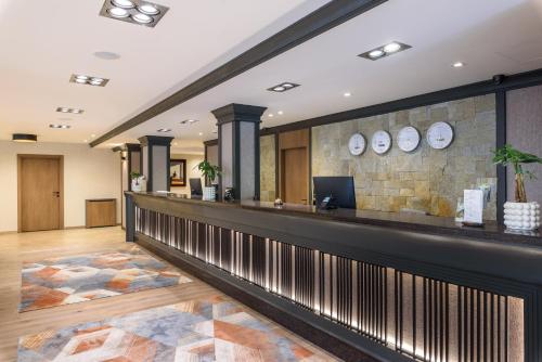 a lobby with a stone wall and a bar at Lion Hotel Borovets in Borovets