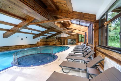 an indoor pool with lounge chairs and a large swimming pool at Lion Hotel Borovets in Borovets