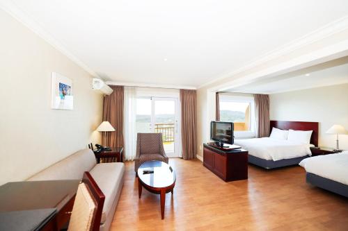 a hotel room with a bed and a couch at La Vie Dor Hotel and Resort, Trademark Collection by Wyndham in Hwaseong