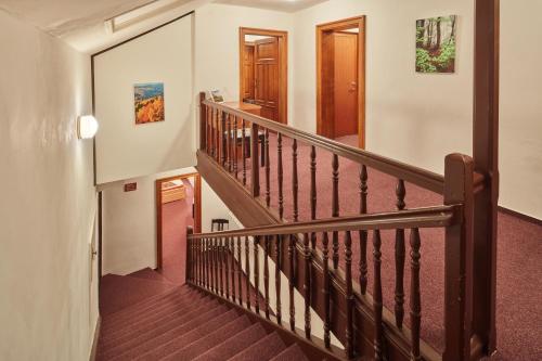 a staircase in a home with wooden railings at Penzion Flora in Janske Lazne