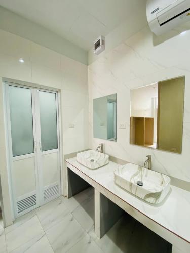 a bathroom with two sinks and two mirrors at MellowDee Female Hostel เมลโลดี โฮสเทลหญิง 女旅社 in Hat Yai