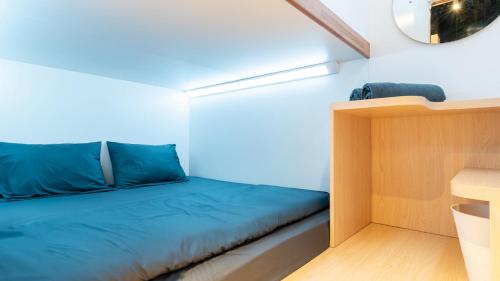 a small room with a bed and a desk at Bobopod Slamet Riyadi, Solo in Solo