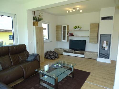 a living room with a couch and a tv at Sunny Side Apartments in Postmünster