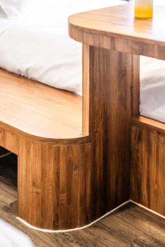 a wooden table with a bed next to a wooden desk at claybed chiangrai in Ban San Ton Ko (1)