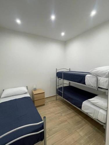 a bedroom with two bunk beds and a wooden floor at Profumi di Sicilia in Cinisi