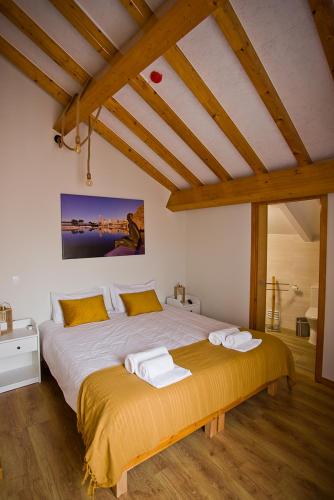 a bedroom with a large bed with two towels on it at Guest House 10 de Agosto in Figueira da Foz