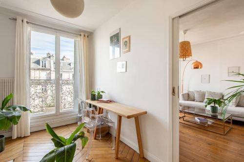 un salon avec une table et un canapé dans l'établissement Le voltaire, à Paris