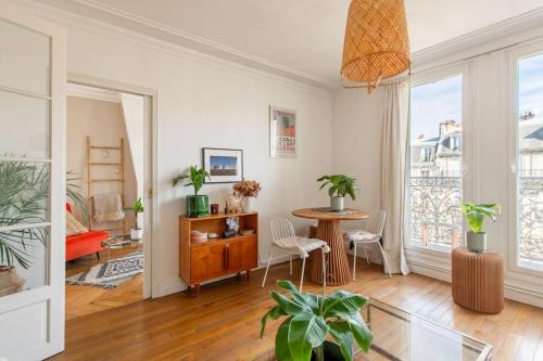 un salon avec une table et des plantes dans l'établissement Le voltaire, à Paris