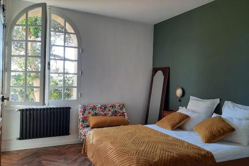 une chambre avec un lit et deux fenêtres dans l'établissement Le Castèl de Lamothe, à Sauternes