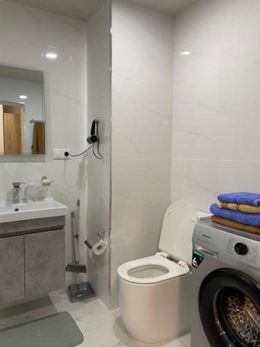 a bathroom with a toilet and a washing machine at Tsaghkadzor Alvina Complex 12 Project in Tsaghkadzor
